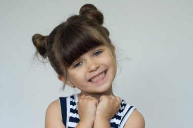 Memnun güzel çocuk gülümseyen eller çene altında tutar.