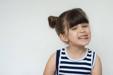 Neşeli güzel çocuk portresi dil beyaz bir arka plan üzerinde gösterir.