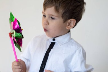 Güzel çocuk plastik bir yel değirmeni üfleme