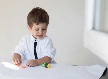 Çocuk oyun parasını beyaz arka plan üzerinde sayma. Mali sorumluluk öğrenme ve tasarruf kavramı planlama.