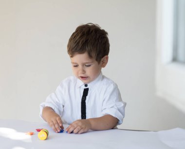 Çocuk oyun parasını beyaz arka plan üzerinde sayma. Mali sorumluluk ve finansal eğitim kavramı.