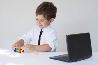 Çocuk bilgisayar ile. Ofis içinde bir laptop önünde oturan genç iş çocuk.