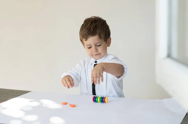 Kid counting his play money on white background. Learning financial responsibility and planning savings concept.