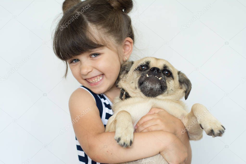 Happy young girl lovingly hugging her dog. Child with funny dog.