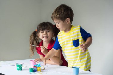 İki çocuk sanat atölyesi oynarken.