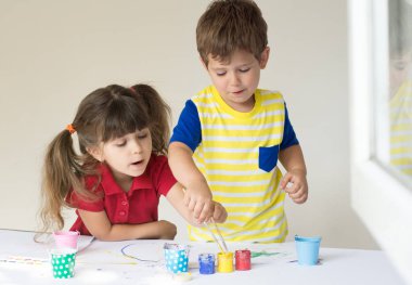 Ev ya da anaokulu oynarken Kilds. Çocuk renkli tişört giymiş.