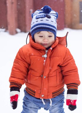 Yürümeye başlayan çocuğu sıcak giysiler kar ile eğleniyor. Kış, Noel ve yaşam tarzı kavramı.