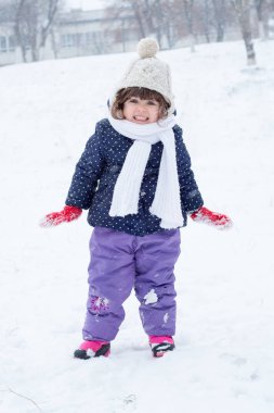 Kış giysileri yağan kar ile şirin çocuk portresi
