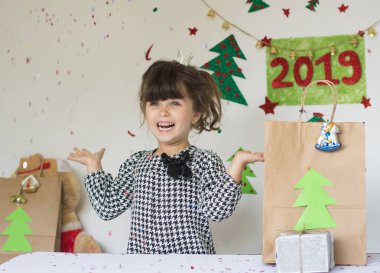 2019 yeni yıl ruh hali. Yakışıklı kız Noel alkış kutluyor. Yeni yıl süsleri güzel duygusal samimi çocuk.