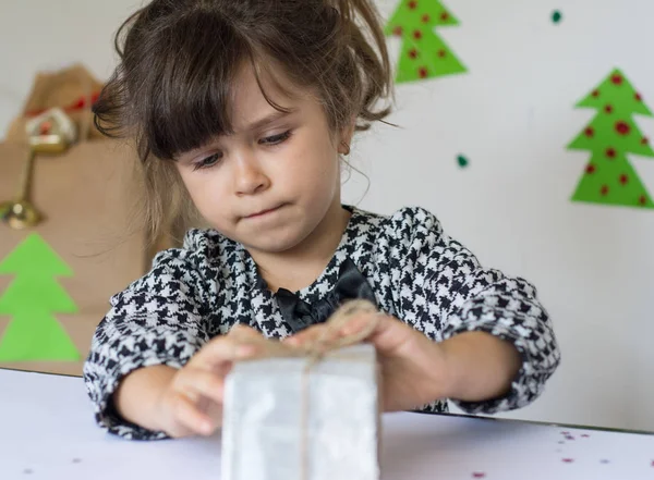 Sad child with giftbox. Christmas time.