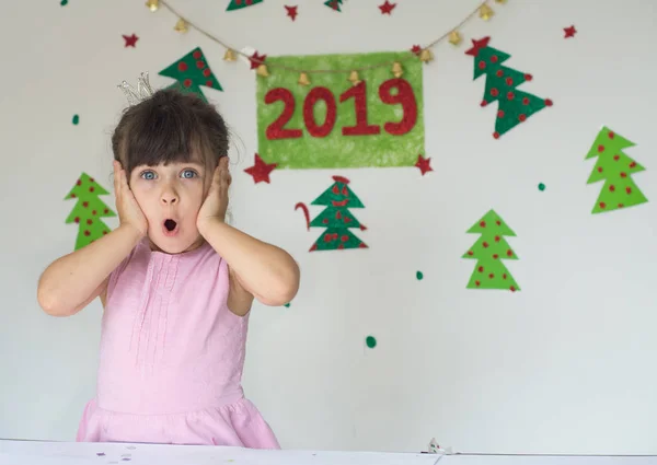 Super! Merry Christmas and 2019 Happy New Year! Portrait of 4-5 years old girl, screaming with open mouth and crazy expression. Surprised or shocked face.