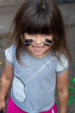 Komik çocuk Büyüteç tutarak kamera, kirli yüzü ve elleri, bak. Öfkeli kirli çocuk gülümsüyor.