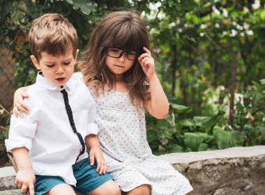 Kız arkadaşı ağlayan yatıştırır. Kız ve erkek kardeşim. İki küçük çocuk birbirlerine sevgi vintage renk tonu bahçesinde ile sarılma. 