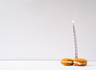 New year's candle and two sweet cakes. Long or large size of penis, the concept of potency, men's Health. With empty free space for text or design. clipart