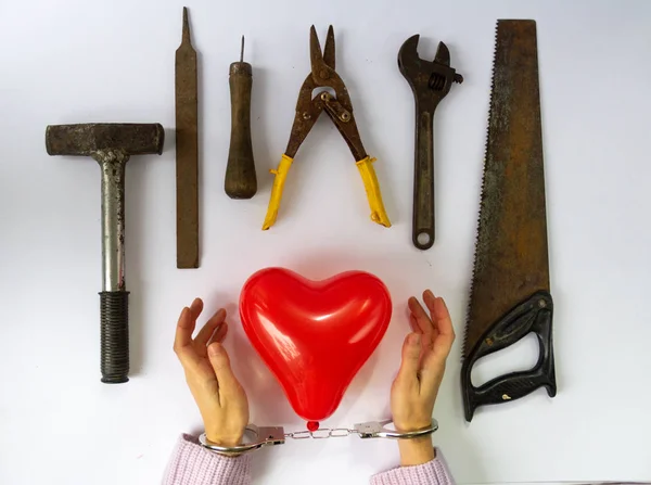 Symbol of love and hand tools. Difficult moment for a woman in a Love Story. Sexual violence, or Domestic violence, sexual abuse.