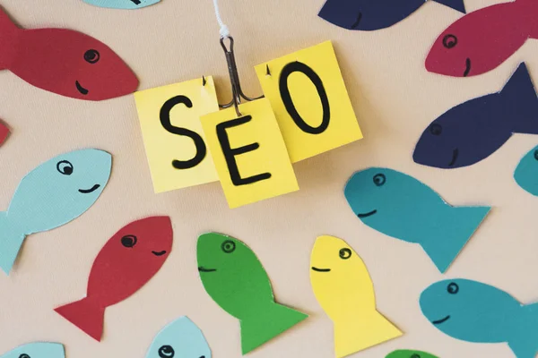 SEO, Search Engine Optimization ranking concept. Group of fishes rushes to fish hook with banner SEO.