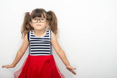 Gözlüklü beyaz arka plan ayakta zeki çocuk. Serin küçük kız kameraya bakıyor.