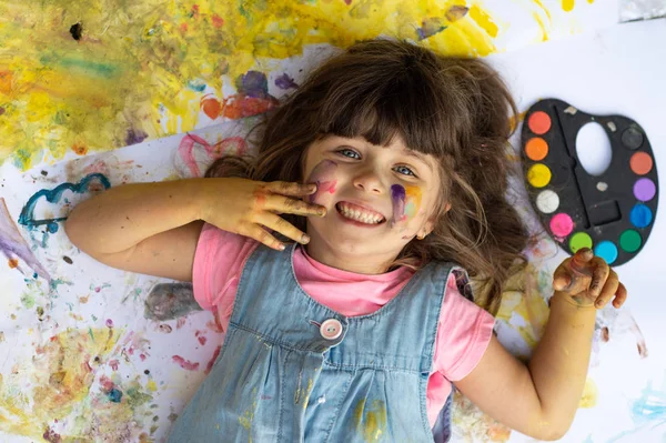 可爱的孩子有乐趣的肖像与手油漆 有趣的小女孩与彩色的脸使用水彩画 — 图库照片