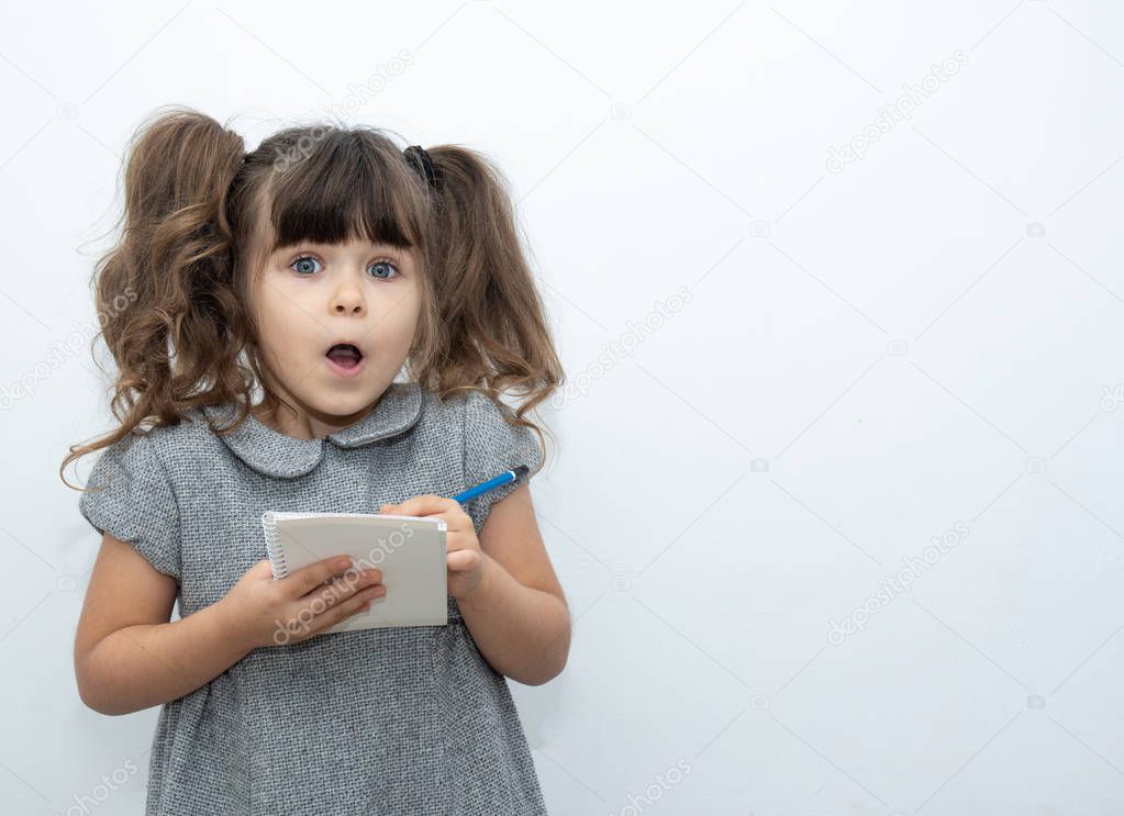 OMG! Child with pen and blank paper book on empty banner on which you can write any text. The concept of childhood and advertising of children's goods. Isolated on white background.