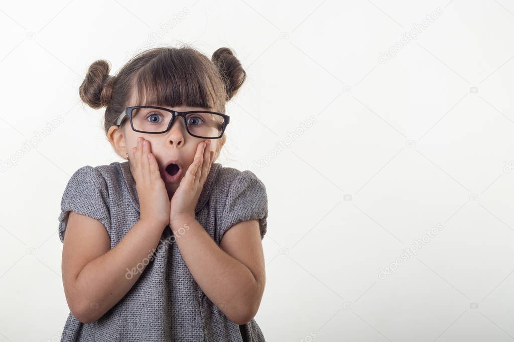 OMG! Wow! Happy surprised child 4-5 years old girl wearing eyeglasses, screaming with open mouth and crazy expression, isolated on white. Shocked face little kid girl on white background.  