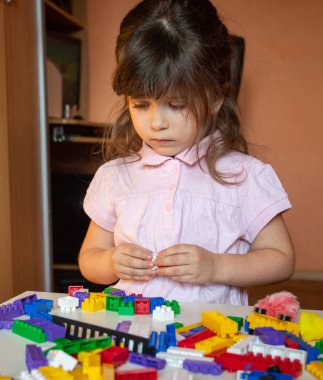 Şirin çocuk yığınları kreş odasındaki masada oturan küpleri oluşturma