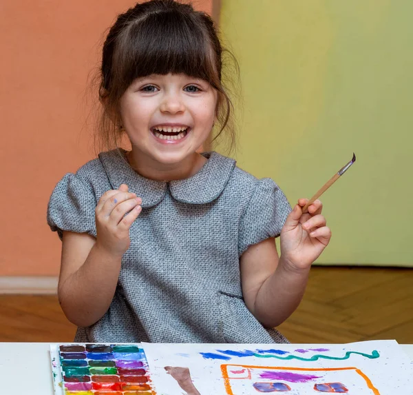 欧洲小女孩在室内的桌子上画画 孩子在她的托儿所里画画 — 图库照片