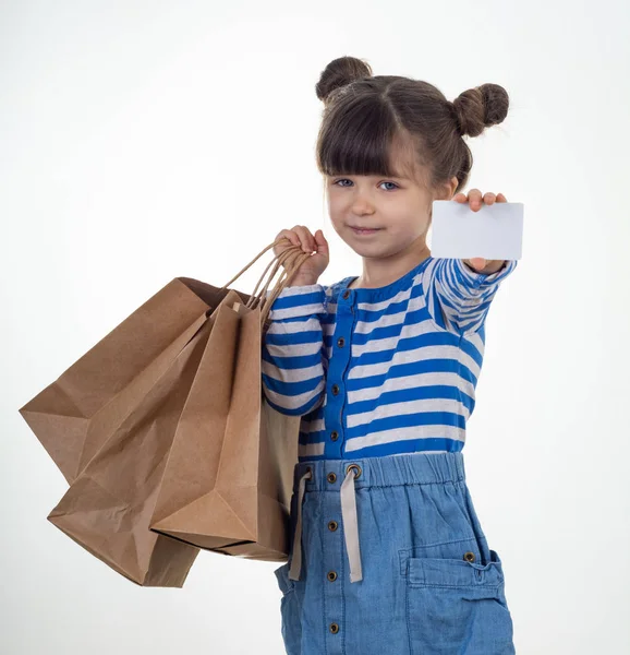 Schattige Lachende Kind Houdt Van Witte Kortingskaart Boodschappentassen Haar Handen — Stockfoto