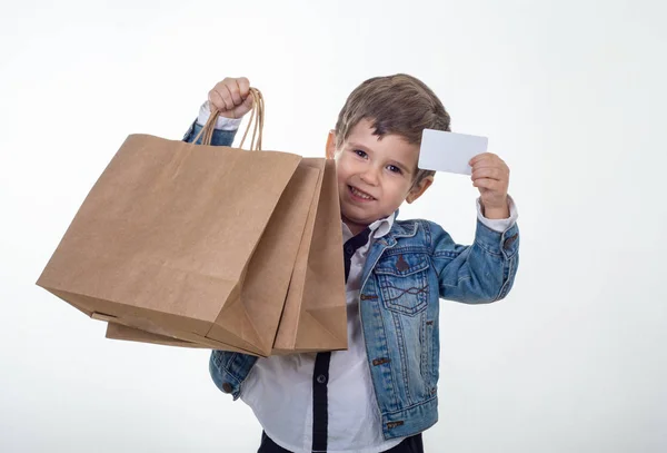 Lindo Niño Sonriente Sosteniendo Descuento Manos Tarjeta Blanca Bolsas Compras — Foto de Stock