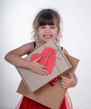 Şirin kız 4 ya da 5 yıl eller Doğum günü hediyesi şenlikli paket içinde tutan gülümseyerek. Beyaz bir arka plan üzerinde izole.
