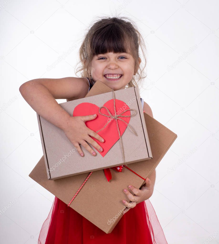 Cheerful child with present. Little smiling girl holding gift box isolated on white. 