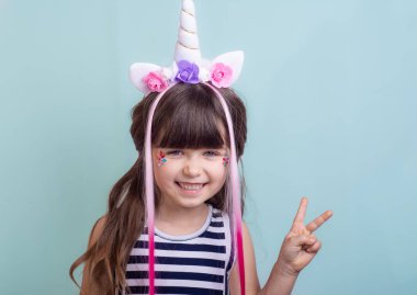 Mutlu ve giden çocuk, zafer ya da barış gösterilen kapalı atış jest ve kamera, pembe bir arka plan üzerinde poz gülümse.