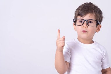 Heyecanlı ve yaratıcı çekici genç çocuk yetiştirme işaret parmağı eureka öneri ekleyerek jest gözlüklü.
