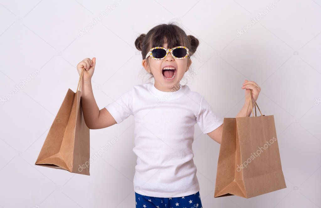 Smiling kid buy purchases. Little girl wearing sunglasses on shopping. 