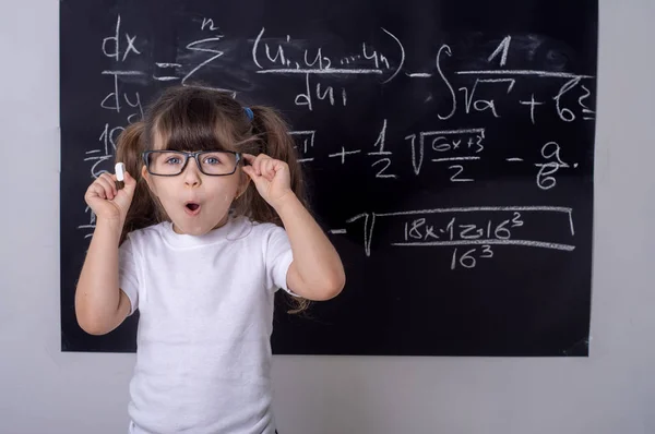 Little school girl in classroom. Smart kid