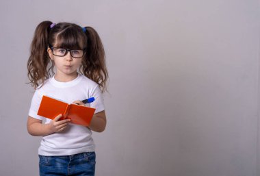 Sevimli kalem tutan ve fikri not defterinde yazı gözlük takar. 