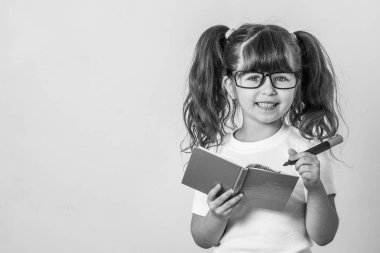 Okul için hazır. Malzemeleri tutan çocuk akıllı ve not defterine yazmak.