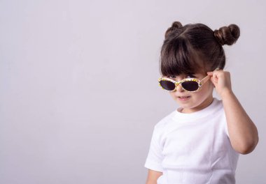 Gülümseyen çocuk güneş gözlüğü giyiyor. Yaz, izole, stüdyo.