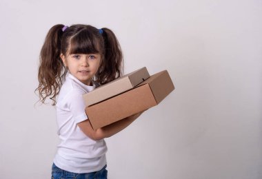 Beyaz arka plan üzerinde izole parsel posta kutusu ile ayakta mutlu bir çocuk görüntüsü. Internet satın alma kavramı.