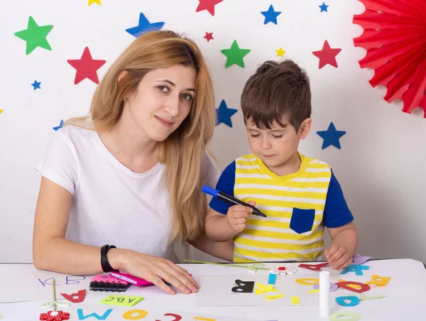 Mother study english letters with child. Parent learning and playing with kid.