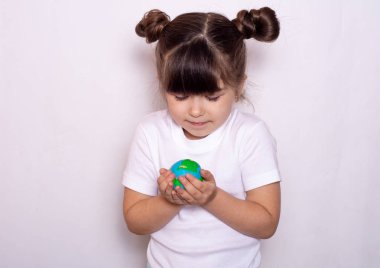 Eller dünya tutarak, beyaz izole yeşil kavram gitmek için kullanılabilir. Gezegenin minyatür modeltutan gülümseyen küçük çocuk. 