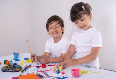 Okul öncesi çocukların sınıfta dersleri var. Beş yaşındaki kız ve üç yaşındaki erkek evde, anaokulunda ya da oyun okulunda çizim yapmaktadır. Sanat, yaratıcı, erken çocukluk eğitimi çocuk kavramı. 