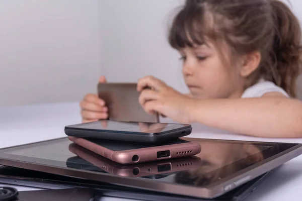 Kid entertaining with phones apps, family gadget addiction concept.