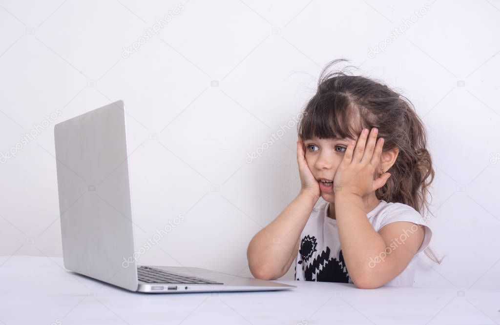 OMG! Shock content. Little girl amazed accidentally watching inappropriate content while surfing the internet. Internet safety.