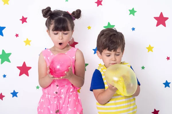 아이들은 분홍색과 노란색 점액에서 거품을 팽창시 아이들은 짜내고 장난감 끈적한 — 스톡 사진