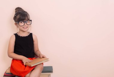 Gri arka plan kitapları olan zeki bir çocuk. Okul için hazır. Okula geri dön. Izole. Küçük Kız kitabı okuyor. 