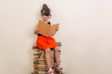 Eğitim ve okuma kavramı. Çalışkan çocuk. Küçük kız kitabı okuyor. Wunderkind.