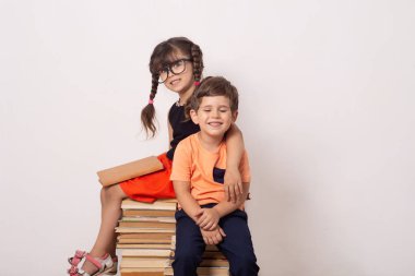 Çalışkan çocuk erkek ve kitaplı kız. Okul çocuklarıyla yaratıcı geçmişe geri dönelim. Sevimli erkek ve kız bilgi seviyor ve okula mutlu.