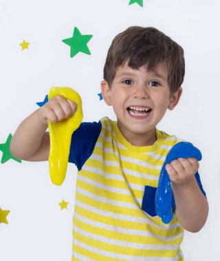 Slime ile sevimli komik çocuk oynamak. Çocuk sıkmak ve streç oyuncak Slime.