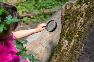 Gündüz leri dışarıda büyüteçli çocuk