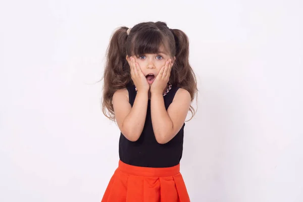 Wow! Surprised brunette child with blue eyes isolated on a white background